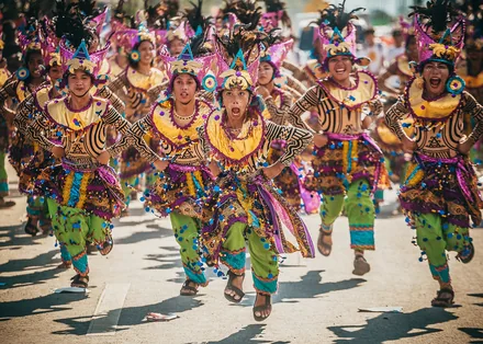 Dansere i fargerike drakter under Sinulog-paraden