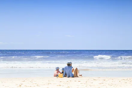 Familie ved en grunn strand