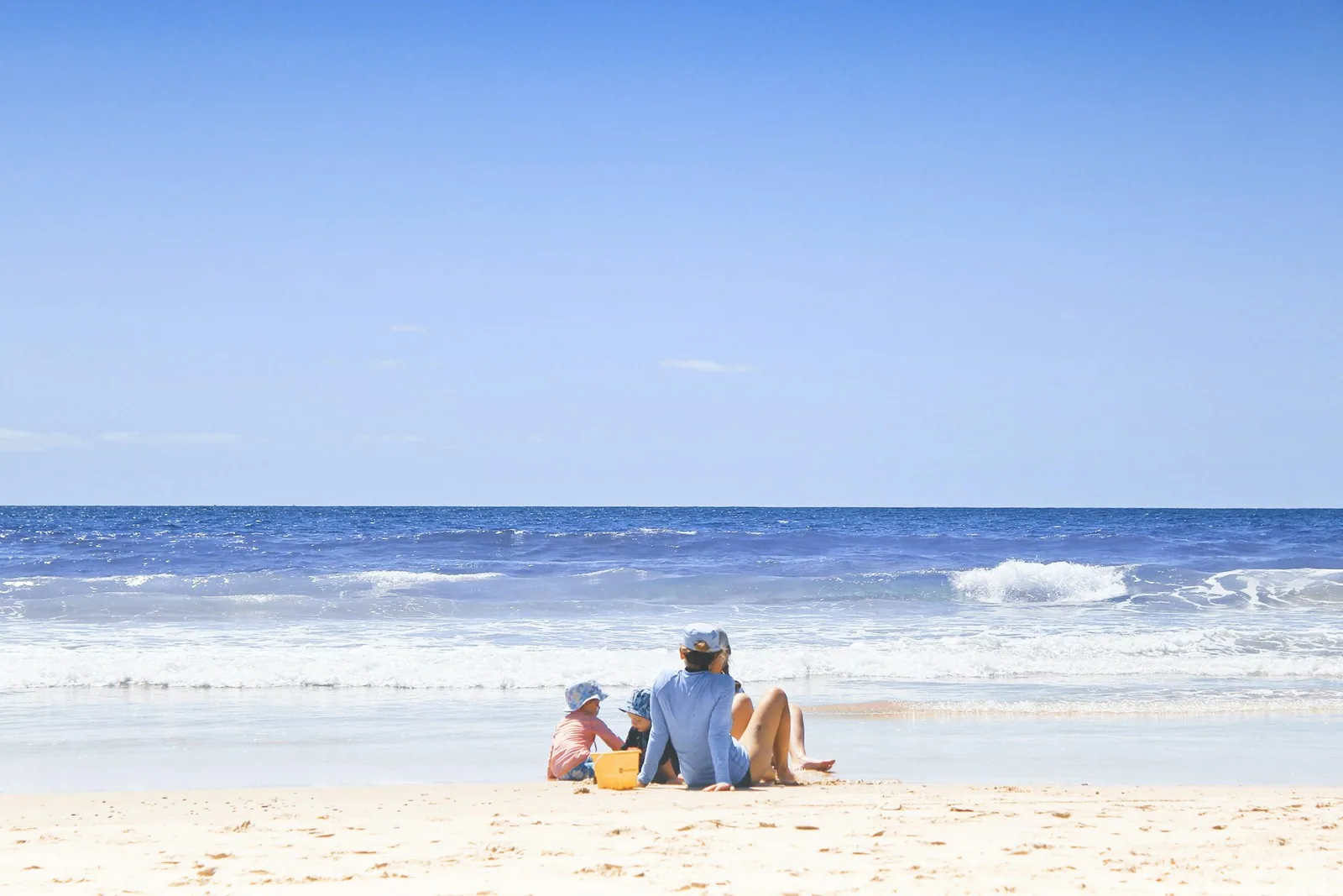 Familie ved en grunn strand